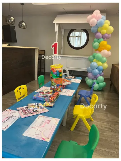 An activity table set up for the kids at the rainbow party, with coloring sheets and games to keep them entertained.