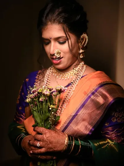 A beautiful, softly lit portrait of the bride holding a bouquet, looking down with a gentle smile.