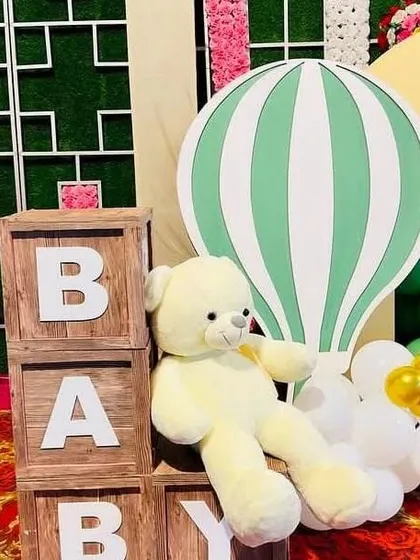 Themed props are key to a great party. For this adventure-themed celebration, I included large wooden "BABY" blocks and a cute teddy bear next to a hot air balloon cutout.