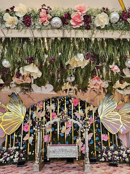 Showcasing my love for whimsical and unique themes, this butterfly-themed naming ceremony features iridescent butterfly wings, a floral cradle, and hanging disco balls for a touch of magic.