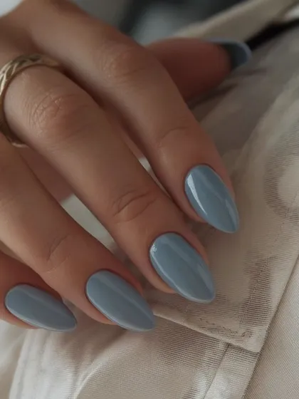 A dusty, muted blue on almond-shaped nails. This is a sophisticated and modern shade.