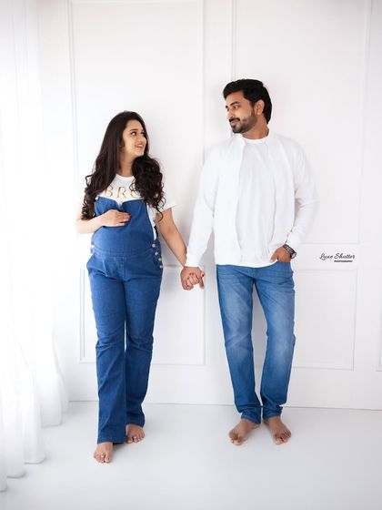 A simple, sweet portrait of the couple holding hands. Their matching casual outfits create a relaxed, relatable, and modern feel for their maternity photos.