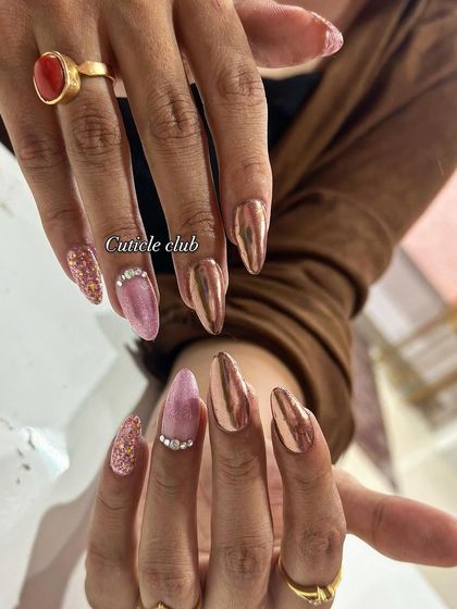 A luxurious combination of rose gold chrome, pink marble, and sparkling glitter on long, elegant nails.