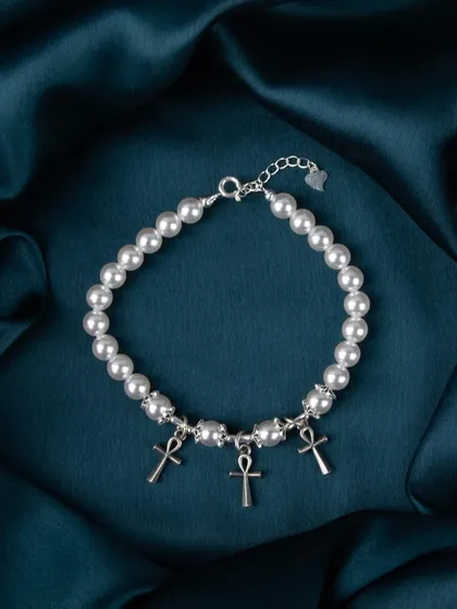 A pearl bracelet with multiple silver Ankh cross charms.