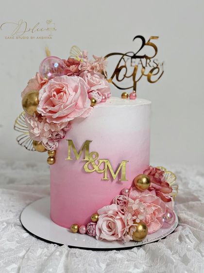 Our bestselling design this season. This pink ombre cake is decorated with a cascade of handcrafted pink flowers and gold accents, perfect for a 25th anniversary.