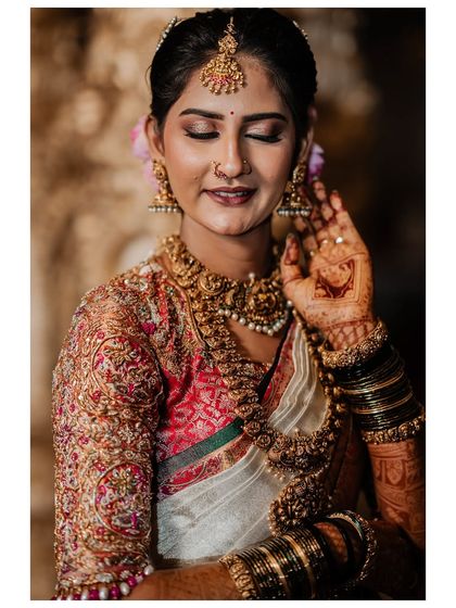 My beautiful client-turned-family, Chethana, looks timeless in this white and pink Kanchipuram saree. I designed a heavily handcrafted bridal blouse with intricate zardozi work to complement the saree's elegance for her special day.
