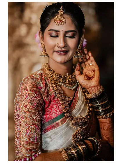 My beautiful client-turned-family, Chethana, looks timeless in this white and pink Kanchipuram saree. I designed a heavily handcrafted bridal blouse with intricate zardozi work to complement the saree's elegance for her special day.