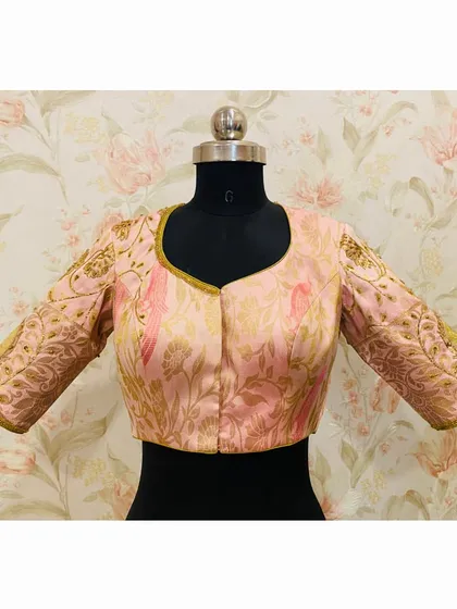 The front of the pink brocade blouse, showcasing the elegant sweetheart neckline and the detailed embroidery on the sleeves.