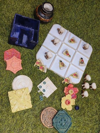 An overview of the diverse ceramic pieces created by a student in our foundation course. You can see a variety of techniques at play, from tile making and sculpting small objects to building functional items like a napkin holder.