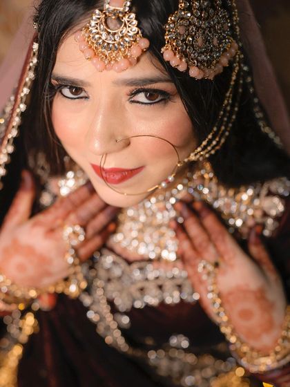 A captivating portrait of a Muslim bride looking directly at the camera, her expressive eyes and beautiful smile drawing you in.