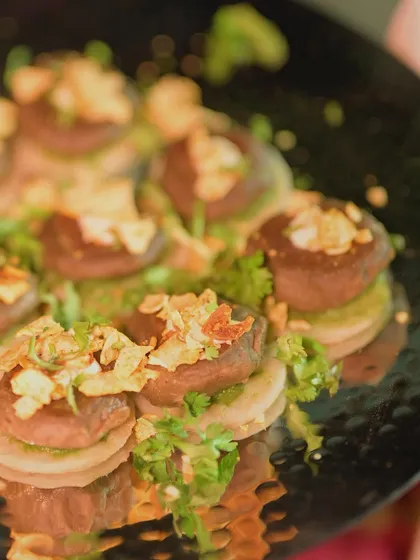 Gul-E-Mushroom, a Mushroom & Goat Cheese Galouti served on a mini laccha paratha. This vegetarian appetizer is rich, creamy, and full of complex flavours.