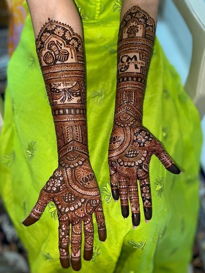 Another angle of the personalized 'CM' mehandi, showing the different motifs on each arm.