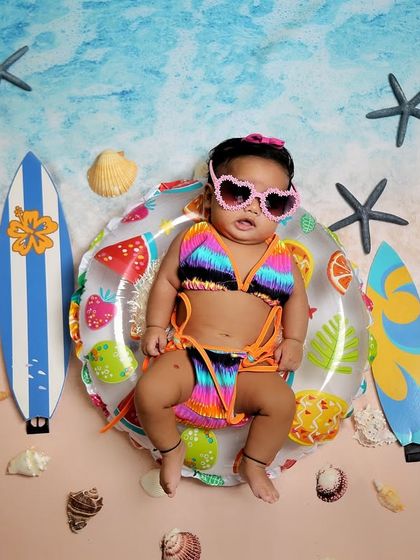 Our little surfer girl is ready for the sun. Dressed in a tiny bikini and heart-shaped sunglasses, she completes our beach-themed twin set.