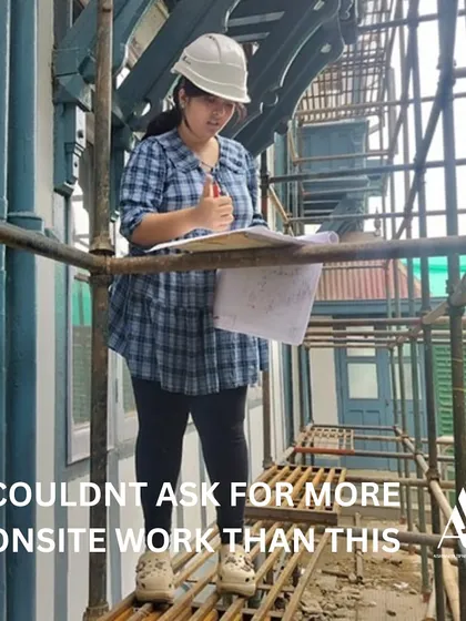 This is what our hands-on internship is all about. An intern stands on scaffolding at a live restoration site, reviewing architectural plans. We believe in learning by doing, and our interns gain invaluable experience in practical site management and conservation techniques.