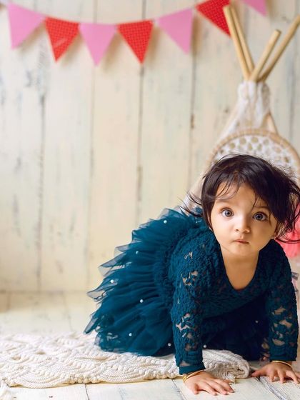 This little explorer is on the move in our boho teepee setup. The rustic wood background and colorful banner add a playful touch.