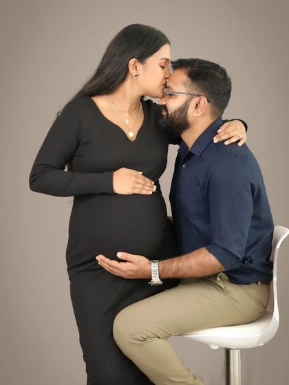 A sweet forehead kiss full of love and promise. This intimate studio portrait captures the deep bond between the parents-to-be in a simple, classic style.