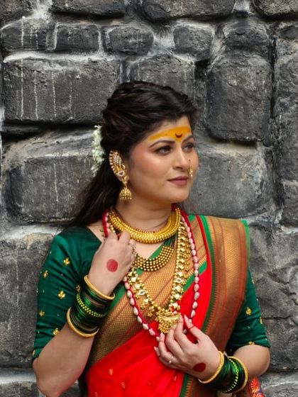 A side profile of Savaniee's look, highlighting the traditional ear cuff and intricate hairstyle.