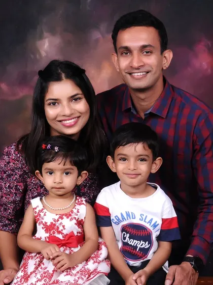 A classic studio family portrait against a warm, painted backdrop. I focus on capturing a relaxed and happy moment with both parents and children looking their best.