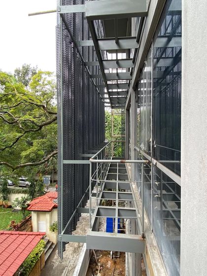 The new steel balconies and walkways are light and transparent, contrasting with the solid mass of the original building. This approach to adaptive reuse architecture adds functionality without overwhelming the existing structure.