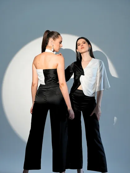 A dual-model shot showcasing contrasting black and white outfits. This type of styling is effective for showing the range and cohesive aesthetic of a collection.