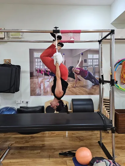 A different perspective of being upside down on the Cadillac. This move is a testament to the strength and control that Pilates builds.