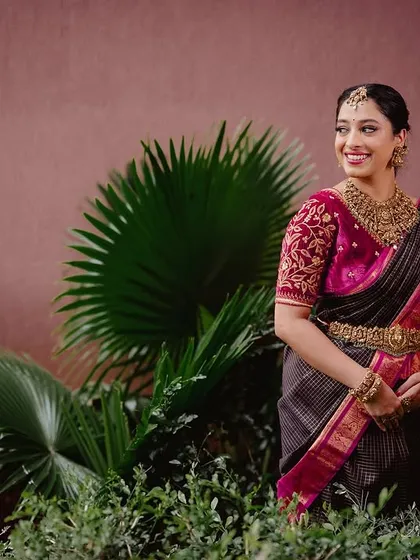 Our client Ansha looks gorgeous in a black and pink checked saree, paired with a heavily embroidered blouse.