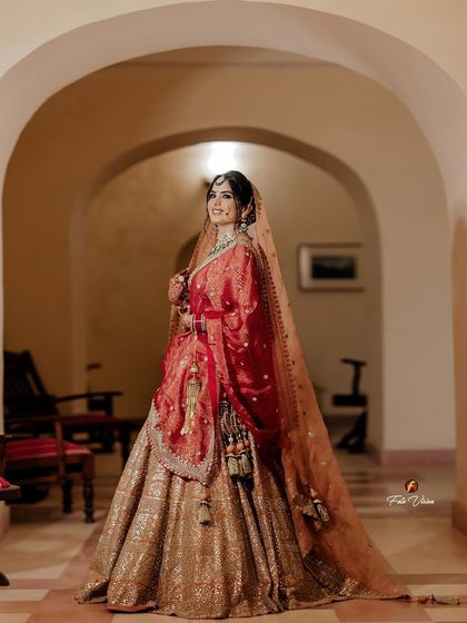 A full-length shot of the bride in a heritage palace corridor, her elegant pose and beautiful lehenga perfectly complementing the royal architecture.