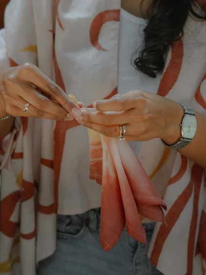 A participant carefully folding her fabric to create a specific tie-dye pattern. The way you fold and tie the material is what determines the final design, making each piece unique.