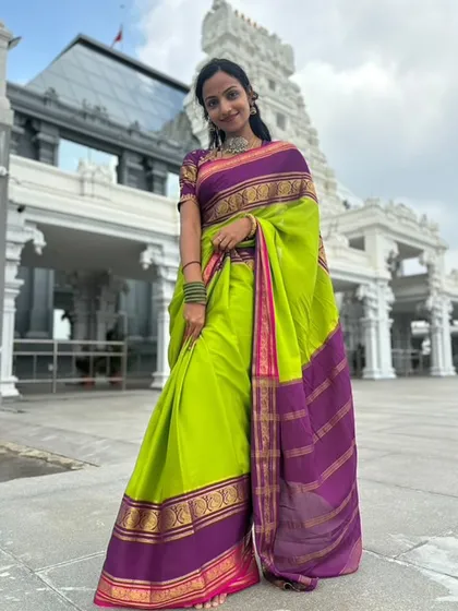 The full temple backdrop with the client looking serene and beautiful in her Dhavala saree.
