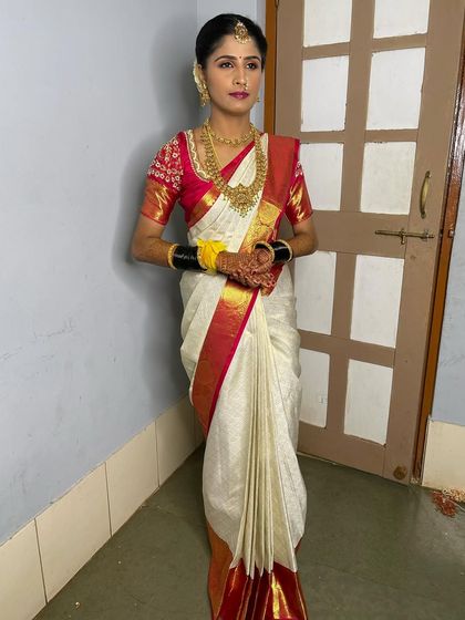 Vathsala looking elegant and poised in her full Muhurtham attire. The classic white and red Kanchipuram saree is a timeless choice for a South Indian bride.