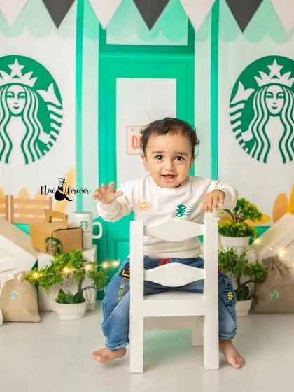 Welcome to the cutest coffee shop in town! This little one is having a blast in our custom Starbucks-themed set, perfect for a unique sitter session.