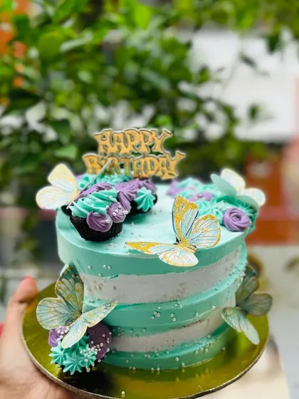 A mint green and white butterfly cake, offering a fresh and unique color combination.