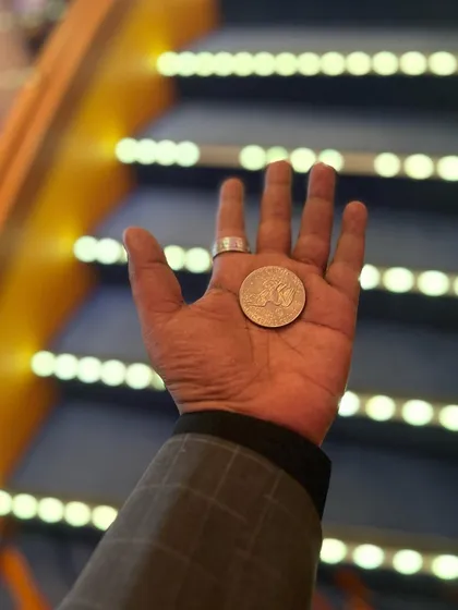 What the hand does, the mind remembers. A close-up shot of a coin, the simple tool for so many magical moments.