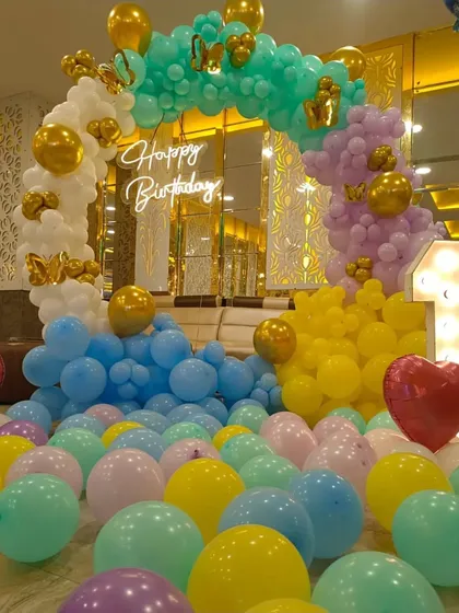 This beautiful pastel balloon arch with a neon sign creates a soft and dreamy photo corner. The loose balloons on the floor add to the playful and celebratory atmosphere.