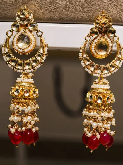 A detailed close-up of traditional gold and pearl jhumka earrings. This shot highlights my expertise in jewelry photography, focusing on intricate details and craftsmanship.