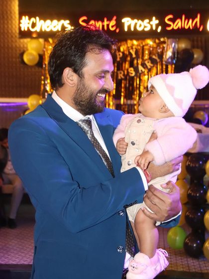 A candid shot of a father lovingly looking at his baby during a birthday celebration.