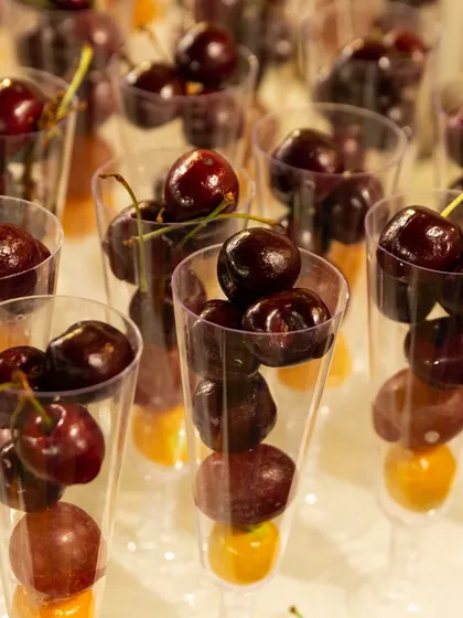 Individual servings of fresh cherries and grapes. This is a convenient and hygienic way to offer fresh fruit at large corporate events.