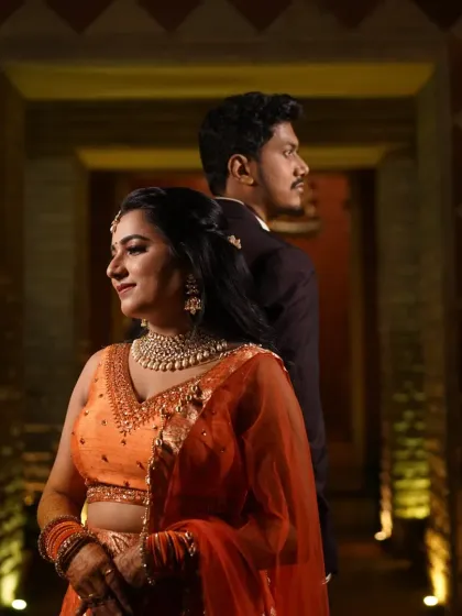 A romantic couple shot from a Sangeet night. The bride's makeup is warm and glowing, designed to look perfect under the evening lights.