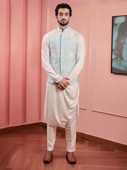 This look showcases modern festive wear. We paired a powder blue bandi jacket, detailed with delicate floral embroidery, with a contemporary draped kurta to create an outfit that is both elegant and effortlessly stylish for daytime events.