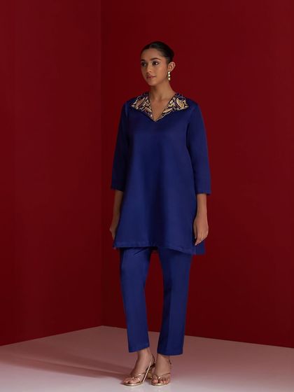 A royal blue A-line kurta paired with matching trousers. The embroidered collar adds a touch of sophisticated detail to the monochrome look.