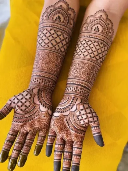 A beautiful example of a full-arm bridal design with a repeating jaal pattern. The symmetry and precision are key to creating this stunning effect.