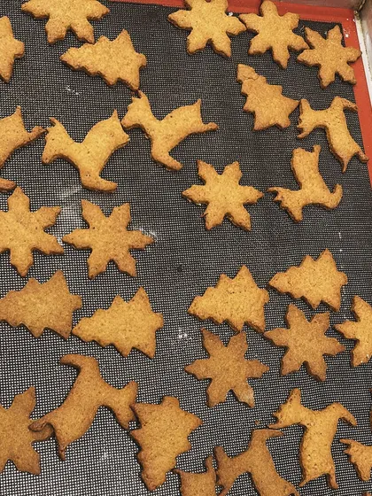 Freshly baked gingerbread cookies cooling on a tray. These festive shapes are made from our signature wholewheat and jaggery recipe, ready to be decorated or enjoyed as is.