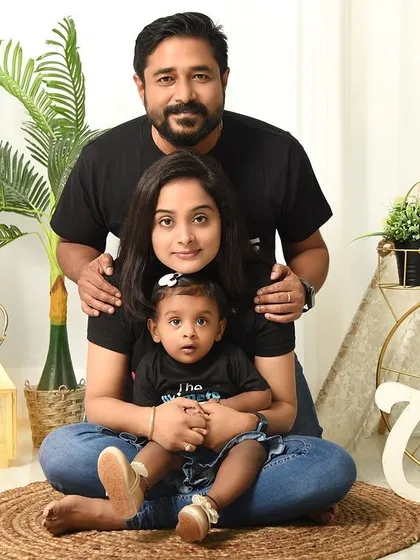 A classic, centered family portrait for a first birthday. The family looks directly at the camera, creating a timeless keepsake of this important milestone.