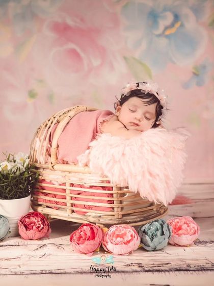 The combination of a rustic basket, soft pink fur, and a floral backdrop creates a dreamy and delicate portrait for this sleeping beauty.