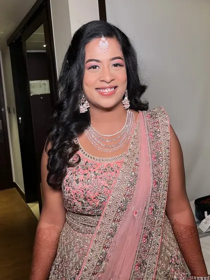 The complete look for Ritu's engagement. The makeup is soft and romantic, perfectly complementing her intricately embroidered pink lehenga.