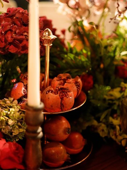 A close-up of the tablescape, showing how we incorporated fresh pomegranates on a tiered stand to add a rich, textural element to the floral arrangements.