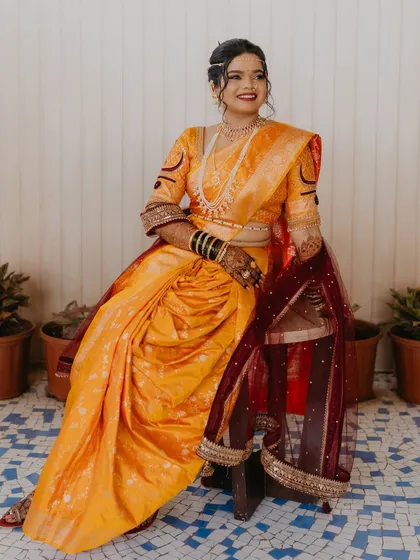 A regal portrait of the bride in her yellow Nauvari saree, looking every bit the traditional queen.