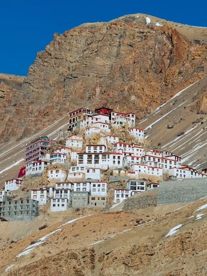 A wide landscape photograph of the Key Monastery, showing its position on the hill against the vast Spiti landscape.