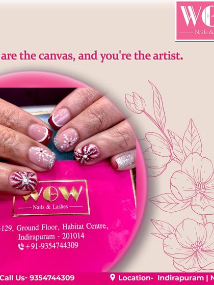 A festive and fun design on short, natural nails. This look combines a glittery base with red and white accents, featuring hand-painted snowflakes and starbursts.