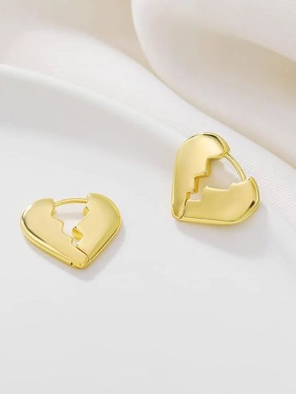 Another view of the broken heart gold plated earrings on a clean white surface.